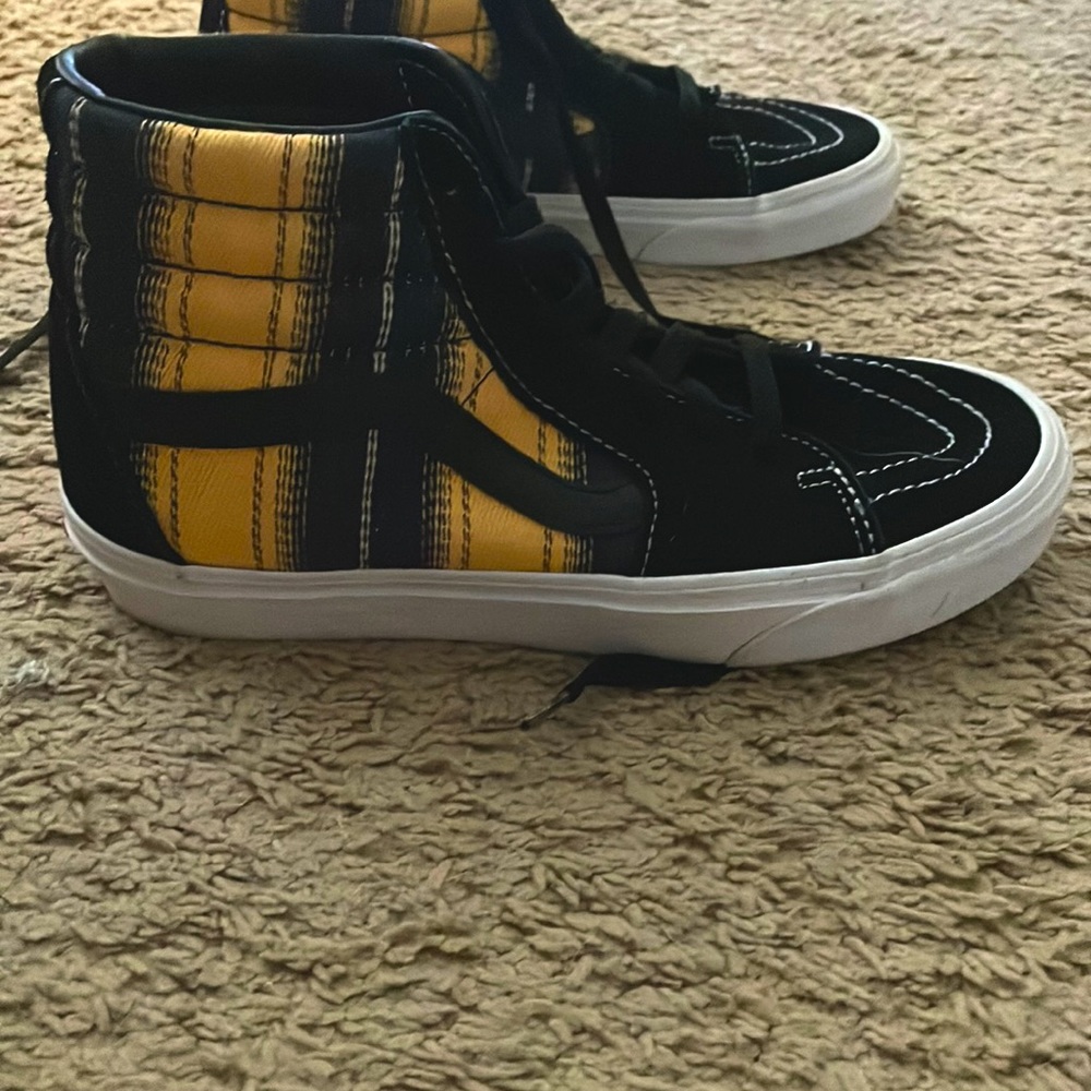 black dark blue golden vans High tops that have a tight fit for when skating.